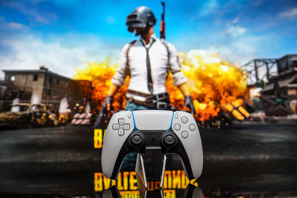 December 20, 2020, Odessa, Ukraine. White new Playstation 5 gamepad on the background of the game PUBG. PLAYERUNKNOWN'S BATTLEGROUNDS cybersport poster concept.