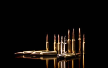 Kurşun, refleksle siyah arka planda izole edilmiş. Tüfek mermileri siyah sırtında. Tüfek ve karabina için siyah fişekler..