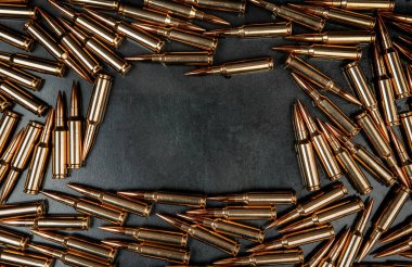 Gri metal arka plandaki tüfek fişeklerinin arka planı. Resmin ortasındaki metin için boşluğu dikdörtgen şeklinde kopyala.