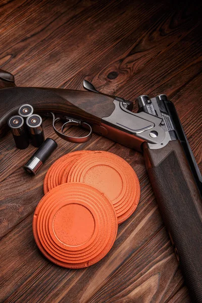 Clay target plates for shooting with rifle on wooden background.