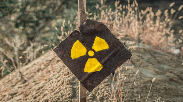 Radiation sign on a rusty metal plate. Hazard warning. Post-apocalyptic sign.