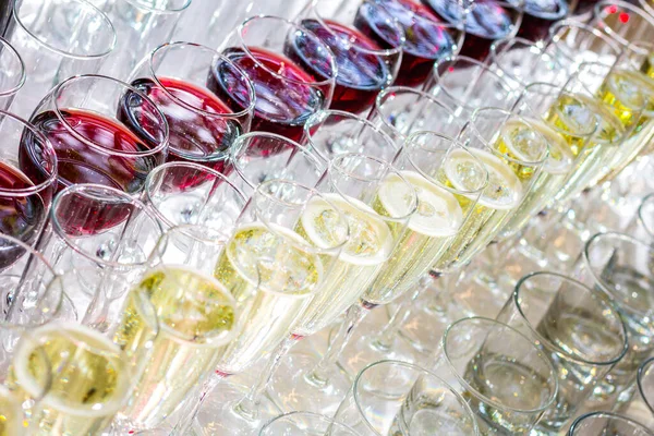 A lot of glasses with white wine and red wine glasses in a row. On the party, wedding.