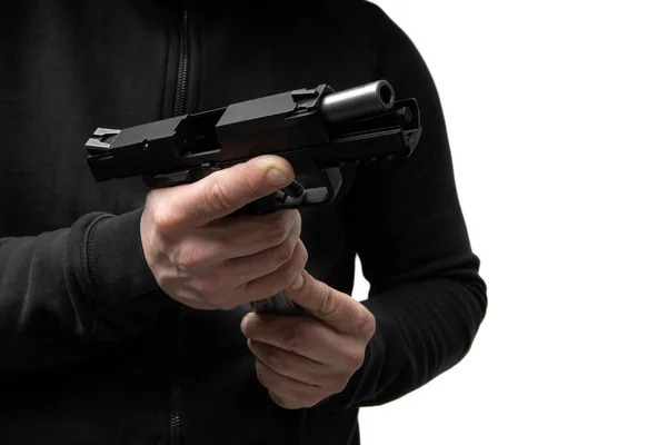 一个穿着深色衣服的人手里拿着一支手枪 重新装上子弹 随手卸下的武器 — 图库照片