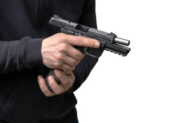 一个穿着深色衣服的人手里拿着一支手枪 重新装上子弹 随手卸下的武器 — 图库照片