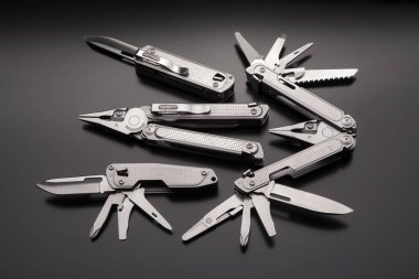 Arka planda katlanan çoklu aletler ve bıçaklar. Metal cep çoklu araçları.