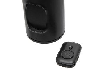 Siyah silindirik bir cihazın yanında kablosuz kamera uzaktan kumandası.