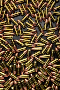 Dağınık altın ve bakır tabanca fişeklerinin tam kare, tepeden görünüşü.