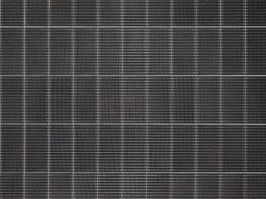 Izgara çizgileri olan karanlık bir fotovoltaik güneş paneli yüzeyinin yakın çekim dokusu.