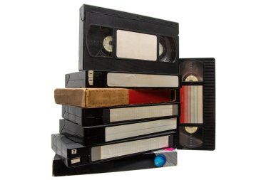 Beyaz arka planda izole edilmiş, boş etiketli bir yığın siyah VHS video kaseti..