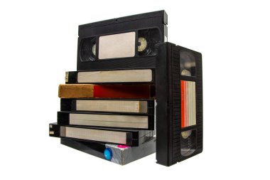 Beyaz arka planda izole edilmiş, boş etiketli bir yığın siyah VHS video kaseti..