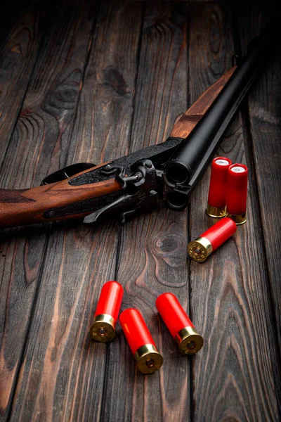 Klasik av tüfeği ve koyu kırsal ahşap arka planda parlak kırmızı kabuklar..