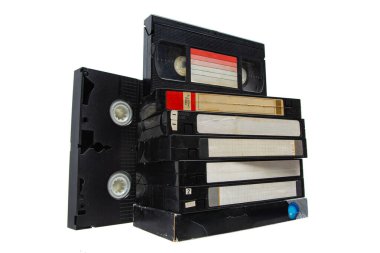 Beyaz arkaplanda izole edilmiş VHS video kasetleri yığını.