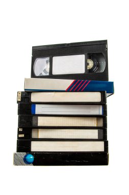Beyaz arkaplanda boş etiketleri olan klasik VHS kasetleri yığını.