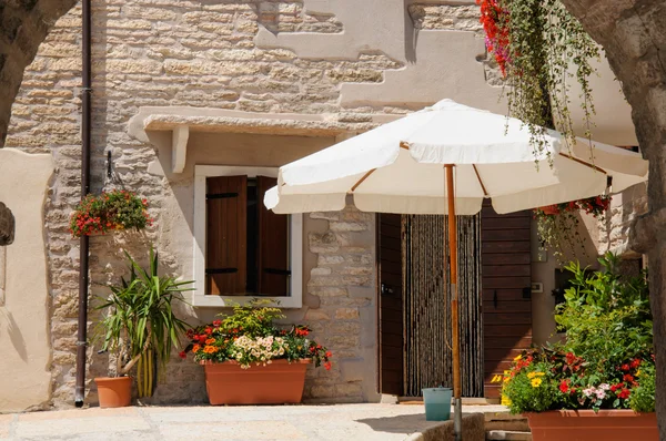 Piękne patio z parasol, kolorowe kwiaty i drzwi drewniane, — Zdjęcie stockowe