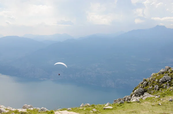 Parapendio sta volando di fronte al paesaggio montano delle Alpi - Mo — Foto Stock