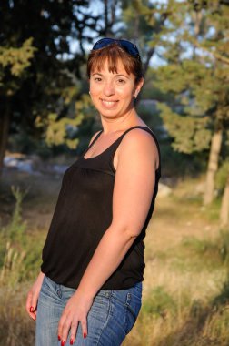 Bir ormandaki gülümseyen güzel esmer 