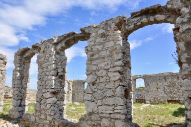 Terk edilmiş ortaçağ kalelerinden oluşan eski yıkılmış duvarlar. Akdeniz şehri Mali Losinj 'de kemerli taş duvarlar. Kemerli antik taş duvar.