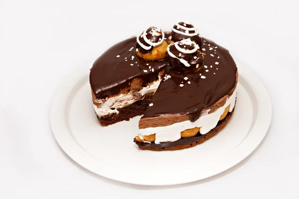 Шоколадный торт с белой крышкой на белой тарелке — стоковое фото