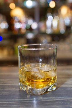 Tahta bir masada bir bardak viski.