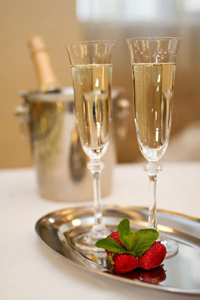 Two glasses of Champagne and strawberries on a table — Stock Photo, Image