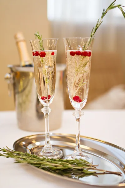 Two glasses of Champagne and rosemary branch on a table — Stock Photo, Image