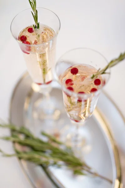 Dos copas de champán y rama de romero en una mesa —  Fotos de Stock
