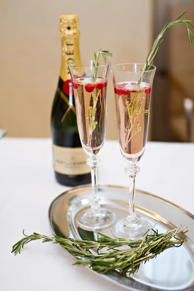 Two glasses of Champagne and rosemary branch on a table — Stock Photo, Image