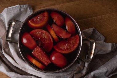 Kırmızı şarap, elmalı ve portakallı şarabı paslanmaz çelikten bir tencereyle evde hazırlarken....