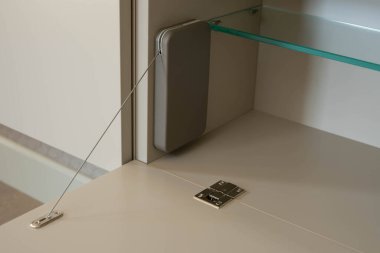 Menteşeli dolap kapısı açık pozisyonda. Kapı menteşesi ve demir kapı tıpası. Modern mobilya teknolojileri