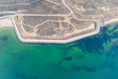 Turkuaz suyla deniz kıyısında. Kavramsal fotoğraf - deniz ve sahil. Helikopter görünümü