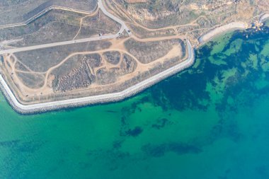 Turkuaz suyla deniz kıyısında. Kavramsal fotoğraf - deniz ve sahil. Helikopter görünümü