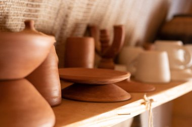 Mağazadaki bir rafta el yapımı toprak eşyalar. Esrar, kase, tabak, kil bardak.