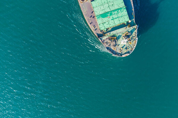 The dry cargo vessel enters the port with the help of tugs. Photo from a helicopter. Bird's-eye view