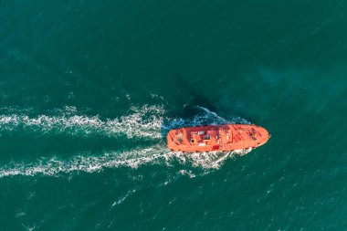 Kılavuz tekne turuncusu dış yollarda gemiyle buluşmaya gider. Helikopter görüntüsü. Denizin üst manzarası