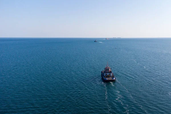 Deniz römorkörü liman su alanından açık denize doğru hareket ediyor. Helikopterden bir fotoğraf. Yukarıdan görüntüle