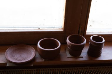 Mağazadaki bir rafta el yapımı toprak eşyalar. Esrar, kase, tabak, kil bardak.