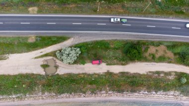 Deniz ve haliçler arasında dar bir tükürük boyunca uzanan bir otoyol. Arabalar yolda. Hava görünümü.