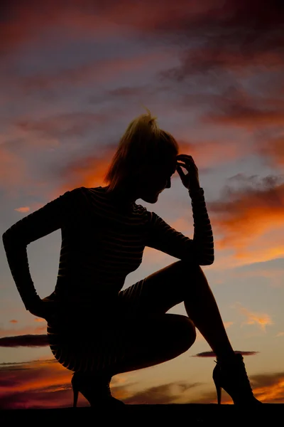 金髪の女性のシルエット クラウチ頭に手 — ストック写真