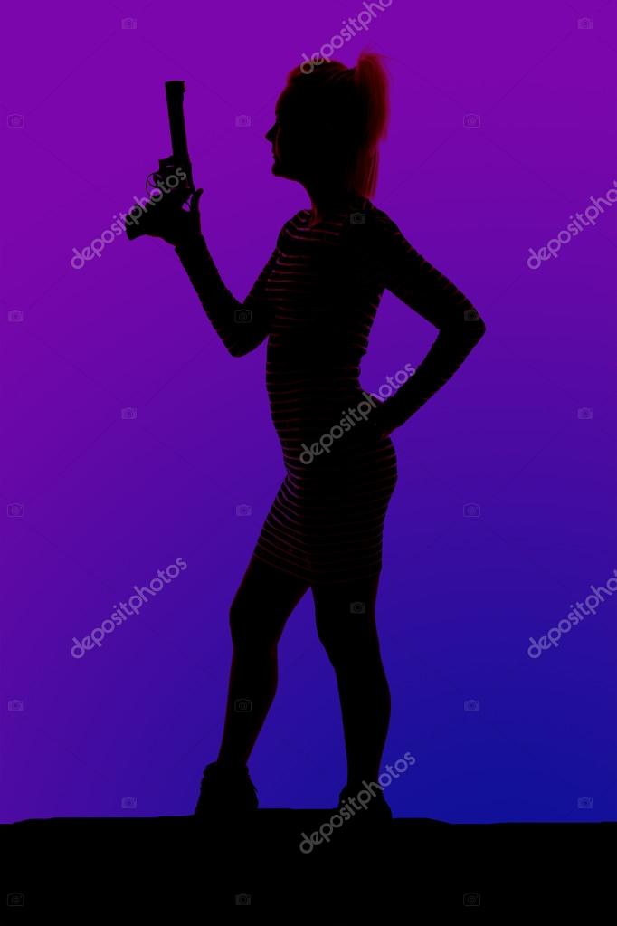 Silhouette of a woman in heels and a dress with gun stand side — Stock