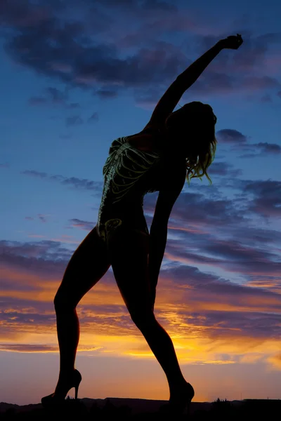 Silhouet van de arm van de terug van de stand van het skelet vrouw de boog omhoog — Stockfoto