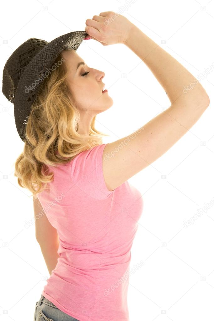 cowgirl in pink shirt black hat side tip head up