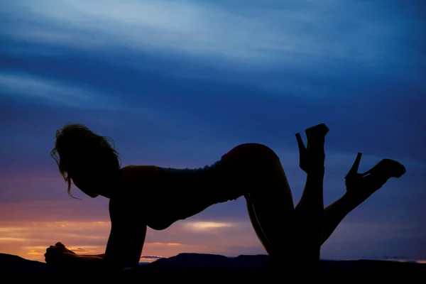 Silhouet van de vrouw op ellebogen en knieën voeten omhoog — Stockfoto