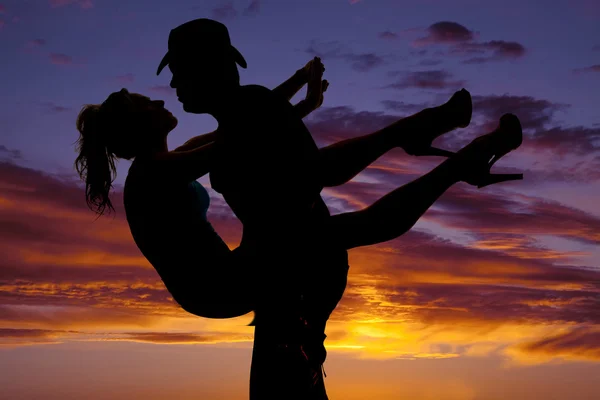 Silhouette of a woman held by man in the sunset — Stock Photo, Image