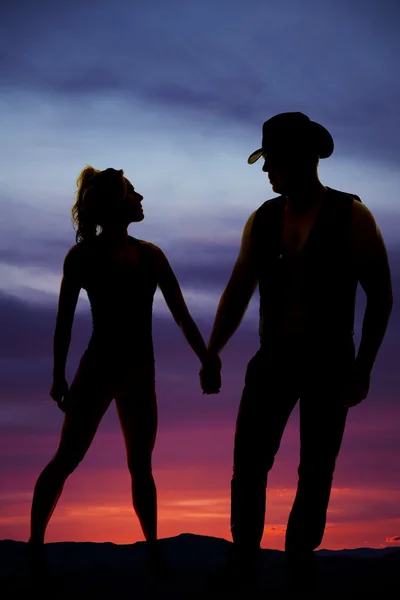 Silhouette of a woman stand hold hands with cowboy — Stock Photo, Image