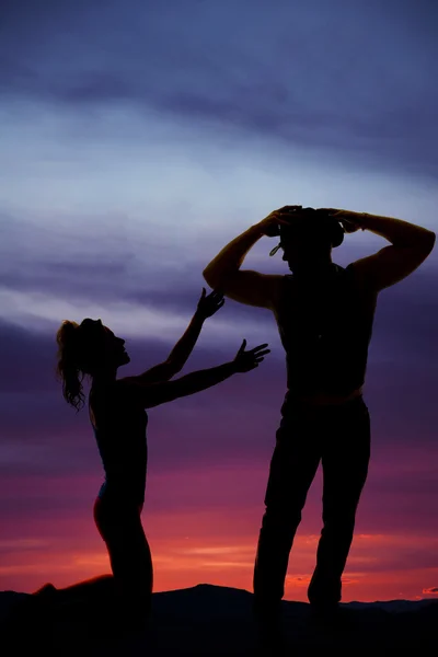 Silhouette of woman on her knees in the sunset reaching up with — Stock Photo, Image