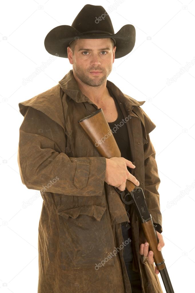 cowboy in black hat and duster holding rifle