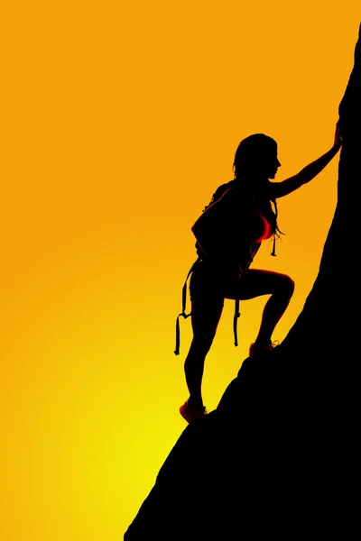 silhouette of woman climbing on rock