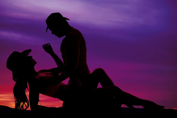 Silhouette of cowgirl lay back reach hand up a little to cowboy — Stock Photo, Image