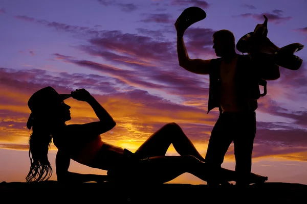 Silhouette di cowgirl sdraiata sul gomito mano sul cappello cowboy — Foto Stock