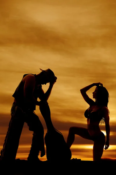 Silhueta de mulher de biquíni lado em um joelho cowboy e guitarra — Fotografia de Stock